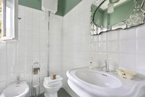 a bathroom with a sink and a toilet and a mirror at Via della Chiesa Apartments in Florence