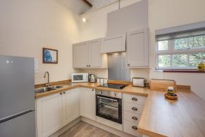 a kitchen with white cabinets and a sink at The Garlic Farm in Sandown