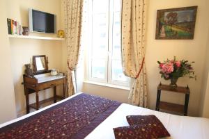 a bedroom with a bed and a window at Hotel des Celestins in Lyon