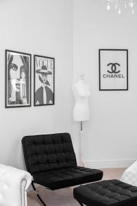 sala de estar con sofá negro y cuadros en la pared en Apartments Warsaw City Center by Renters, en Varsovia