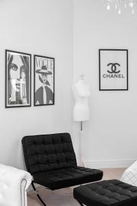 salon z czarną kanapą i obrazami na ścianie w obiekcie Apartments Warsaw City Center by Noclegi Renters w Warszawie