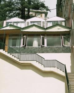 a house with stairs in front of it at Hotel Lords Regency in Shimla