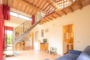 uma sala de estar e cozinha com uma escada numa casa em La Sorgente em Capannoli