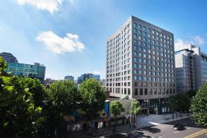 ein hohes weißes Gebäude in einer Stadtstraße in der Unterkunft Orakai Daehakro Hotel in Seoul