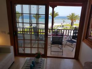 a living room with a view of the beach at Playa del Duque in 1st sea line directly on the beach, heated pool, Wifi, balcony in Adeje