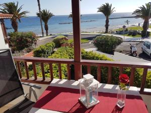 a table on a balcony with a view of the ocean at Playa del Duque in 1st sea line directly on the beach, heated pool, Wifi, balcony in Adeje