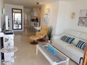 a living room with a couch and a table at Playa del Duque in 1st sea line directly on the beach, heated pool, Wifi, balcony in Adeje