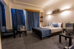 a hotel room with a bed and a chair at Cleopatra Hotel in Aswan