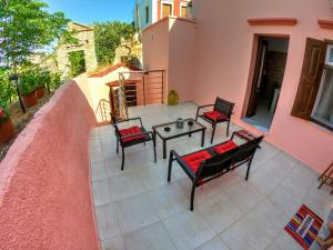 a patio with chairs and a table on a house at Armonia House in Symi