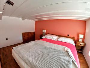 a bedroom with a white bed with a red wall at Armonia House in Symi