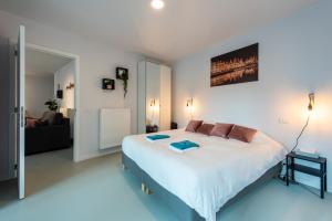 a bedroom with a large bed and a living room at Salt & Pepper Ghent in Ghent