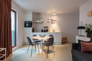een keuken en een woonkamer met een tafel en stoelen bij Salt & Pepper Ghent in Gent