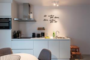 a kitchen with white cabinets and a sink at Salt & Pepper Ghent in Ghent +4 photos