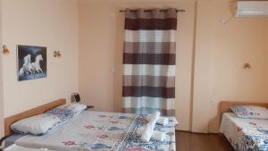 a bedroom with two beds and a curtain at Sunshine in Gevgelija