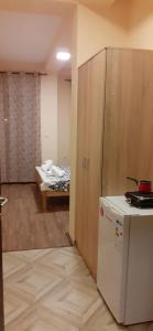 a kitchen with a refrigerator and a room with a bed at Sunshine in Gevgelija