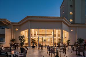 a restaurant with tables and chairs and a building at Lindos Royal Resort in Líndos