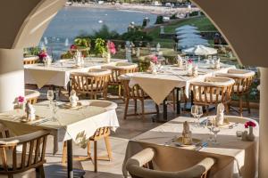 a restaurant with tables and chairs with a view of the ocean at Lindos Royal Resort in Líndos