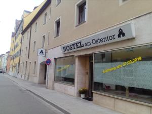 ein Gebäude mit einem Schild an der Vorderseite eines Ladens in der Unterkunft Hostel am Ostentor in Regensburg