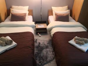 Dos camas en una habitación de hotel con animales de peluche. en CENTRAL STUDIO HUNEDOARA, en Hunedoara