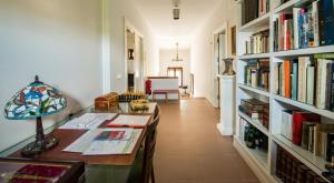 een kamer met een bureau en een boekenplank met boeken bij Casa Rural en Cigarral de Villamarta Toledo con piscina y WIFI in Toledo