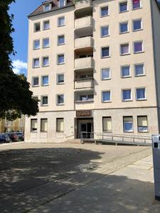 a large white building with a parking lot in front of it at Pension Reiter in Berlin