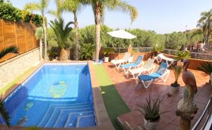 a swimming pool on a patio with chairs and a table at VILLA SOFIA CALELLA in Calella