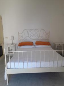 a white bed with orange pillows in a bedroom at Sweet Home in Ischia