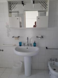 a white bathroom with a sink and a mirror at Sweet Home in Ischia