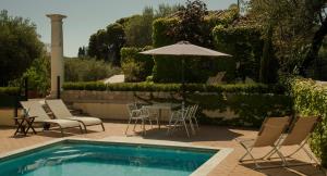 a pool with chairs and a table with an umbrella at Casa Rural en Cigarral de Villamarta Toledo con piscina y WIFI in Toledo
