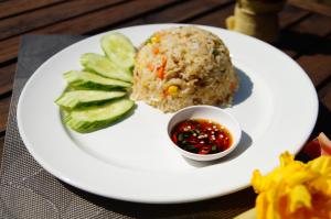 a white plate of food with rice and vegetables at Thakhek Travel Lodge in Thakhek