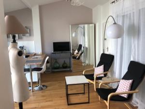 a living room with chairs and a table and a mirror at studio maisonnette avec jardin, Nancy Thermal, Artem in Nancy