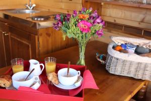 einen Tisch mit einer Vase Blumen und einer Vase Brot in der Unterkunft Hôtel & Spa Chai De La Paleine in Le Puy-Notre-Dame
