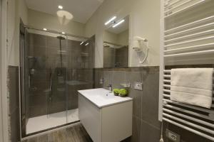 a bathroom with a sink and a shower at Hotel Repubblica 55 in Biella