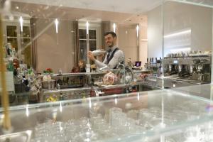 a man standing behind the counter of a bar at Hotel Repubblica 55 in Biella
