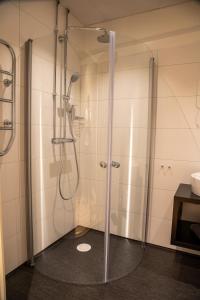 uma casa de banho com um chuveiro e uma porta de vidro em Hotell Syfabriken em Falköping
