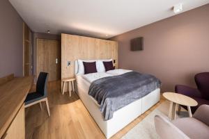 a bedroom with a large bed and a desk at Lamondis in Castelrotto
