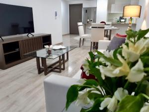 een woonkamer met een bank en een tafel met bloemen bij Foresta Boutique Apartments in Quito