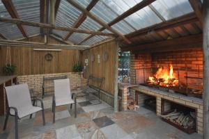 an outdoor patio with a fireplace and two chairs at IRONWOOD LODGE in Pennington