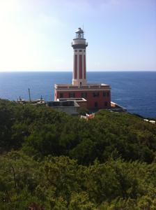 a lighthouse on top of a hill next to the ocean at La Rotonda in Anacapri