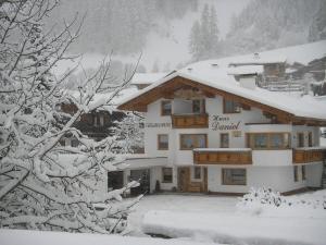 un edificio cubierto de nieve con un cartel. en Haus Daniel, en Neustift im Stubaital
