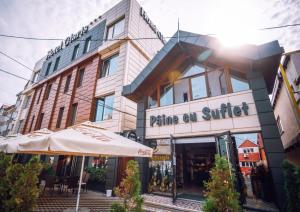 un bâtiment avec un parasol devant lui dans l'établissement HOTEL GLARIS, à Tîrgu Frumos