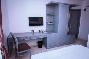 a bedroom with a desk with a tv and a bed at HOTEL GLARIS in Tîrgu Frumos