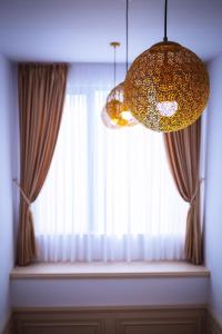a large window with curtains and a chandelier at HOTEL GLARIS in Tîrgu Frumos
