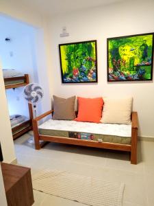 a couch in a room with two paintings on the wall at The Best View in Angra dos Reis