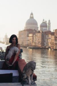 una mujer sosteniendo un bebé y un perro en un barco en Palazzetto Pisani Grand Canal en Venecia