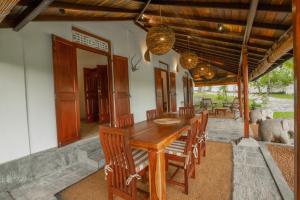 a dining room with a wooden table and chairs at Villa Godahena in Ambalangoda