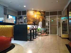a restaurant with a bar with stools in a room at Boston Hotel in Chiayi City