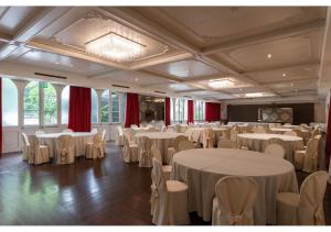 a banquet hall with white tables and chairs at Phi Hotel Canalgrande in Modena