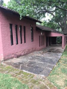un edificio de ladrillo rosa con muchas ventanas en Nyangombe Backpackers, en Kwekwe