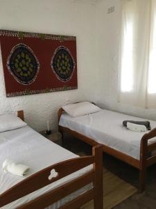 Cette chambre comprend 2 lits et une photo murale. dans l'établissement Nyangombe Backpackers, à Kwekwe